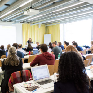 des étudiants et étudiantes de dos dans une salle de classe